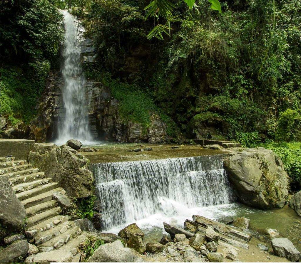 Water falling through green mountains at Banjhakri Falls near Gangtok