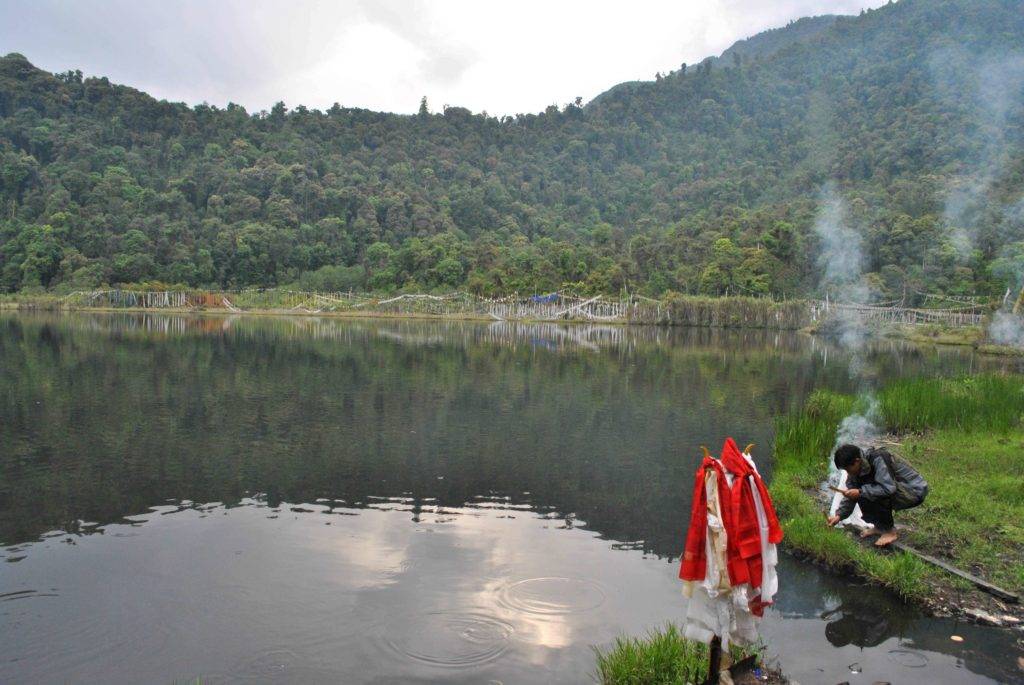 Still waters of Khechiperi Lake surrounded by green mountains